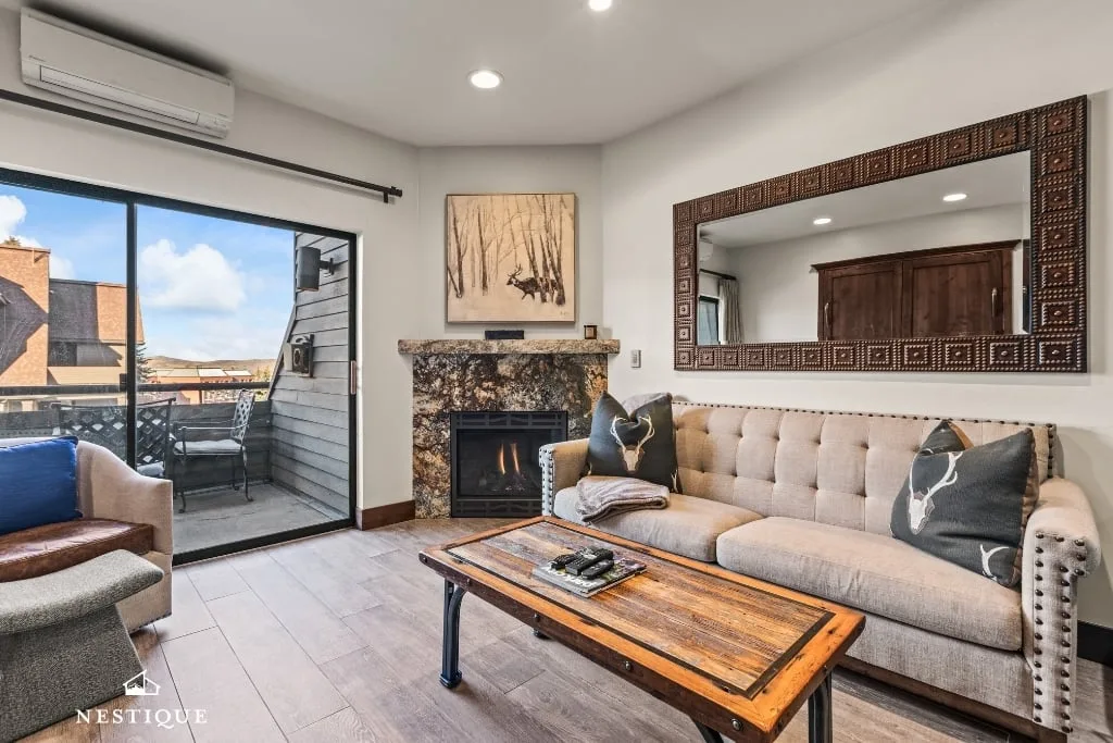 Living room with fireplace and balcony at Parkside Paradise at Mountain Village, Park City